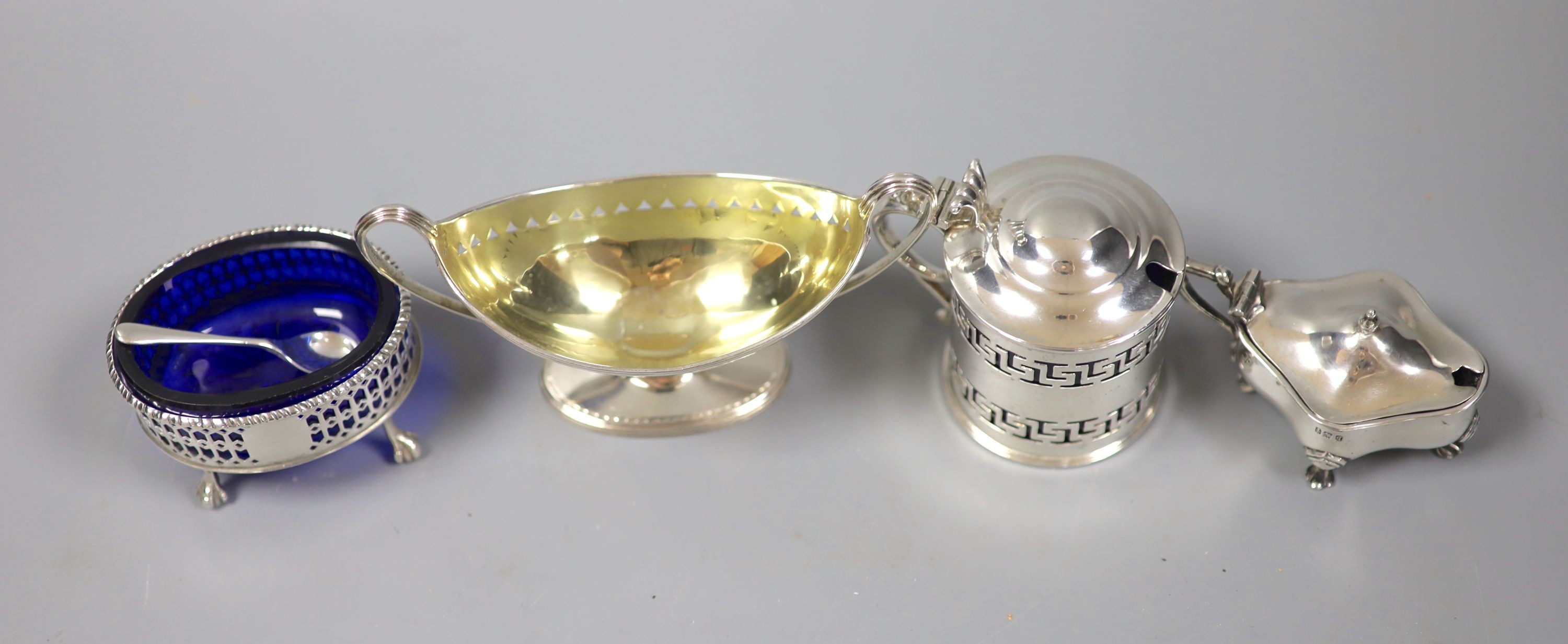 A George III silver two handled boat shaped pedestal salt, London, 179, one other salt and two later silver mustards.